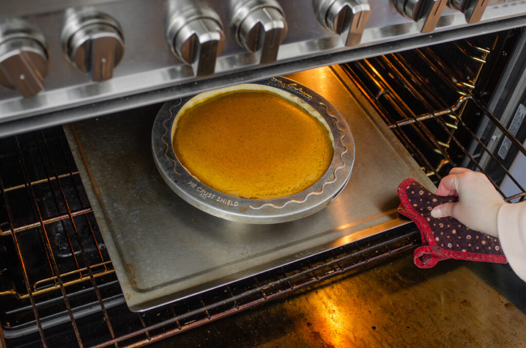 Testing a pumpkin pie to see if it's done by wiggling it.