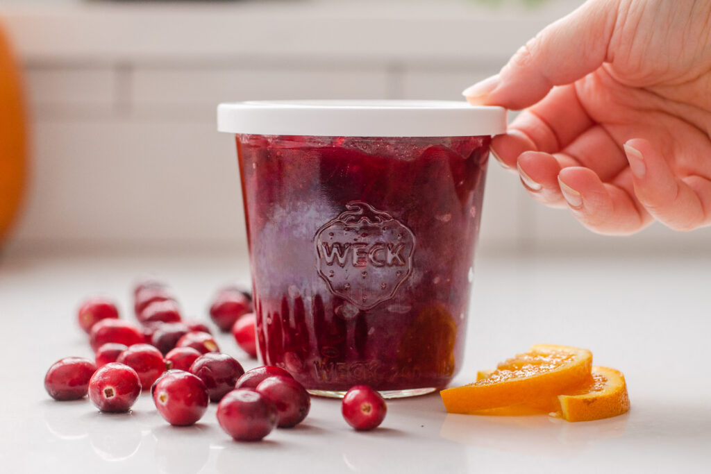 Placing the organic cranberry sauce in a Weck jar for storage.