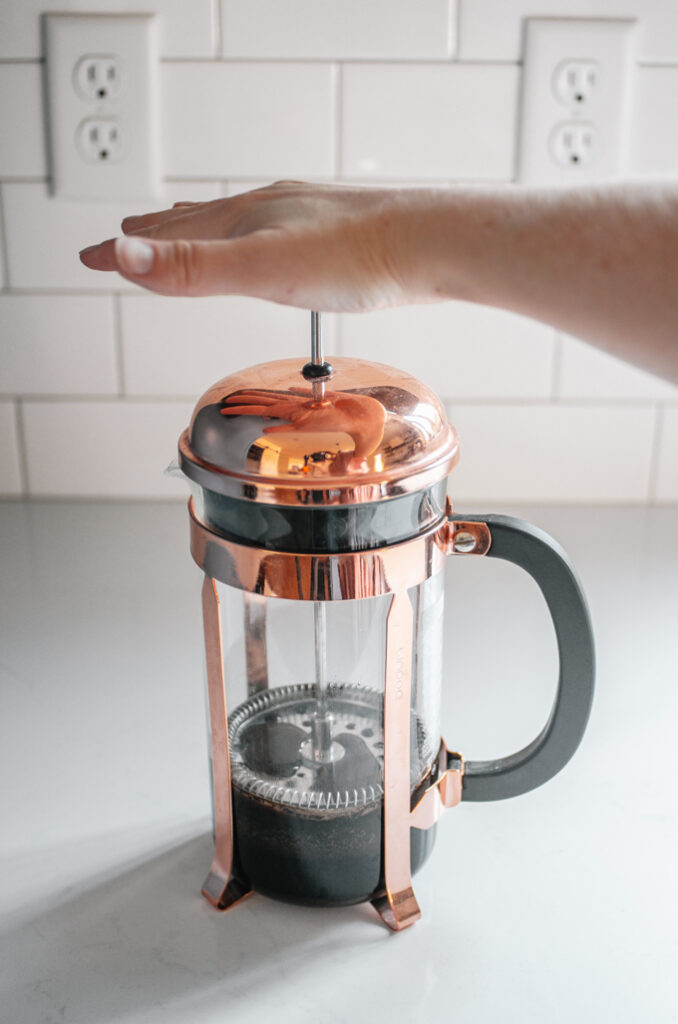 Making cold brew coffee with milk in a french press, also known as a  cafetière, coffee press, or coffee plunger Stock Photo