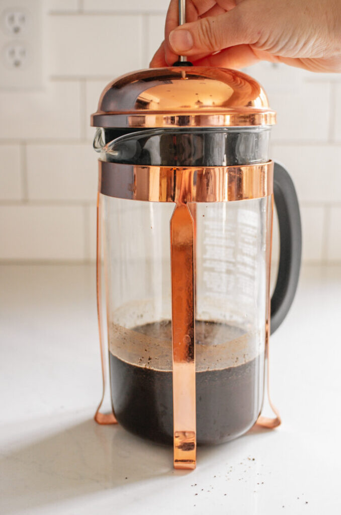 Placing the lid on top of the French press.