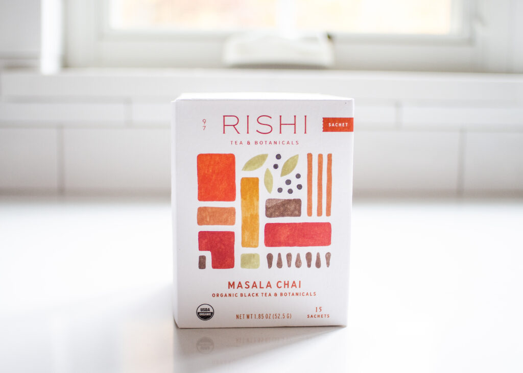 Rishi Masala Chai on a white countertop with a window in the background.