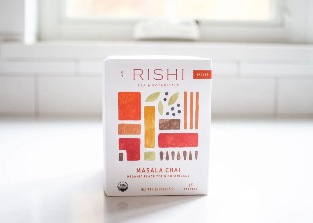 Rishi Masala Chai on a white countertop with a window in the background.