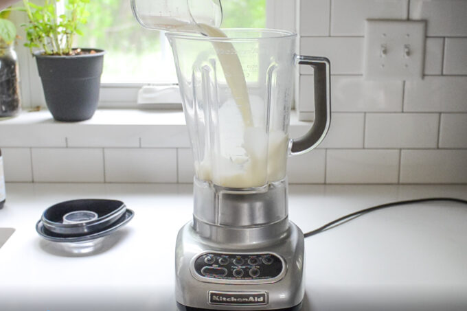 Pouring the milk into the blender pitcher. 