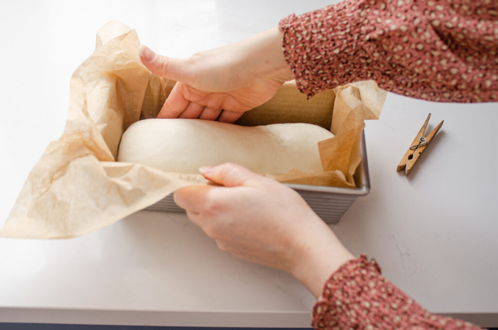 Transferring the dough to the prepared loaf pan.