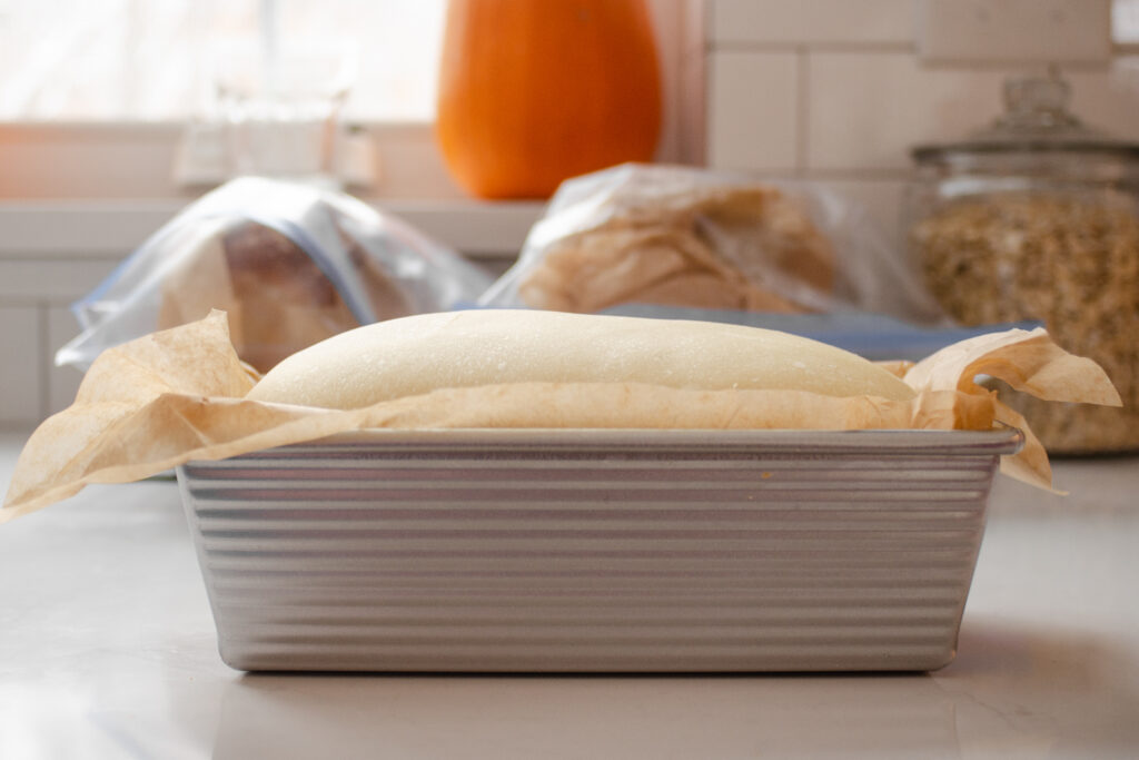 The risen loaf of sourdough sandwich bread, ready to be scored and baked.