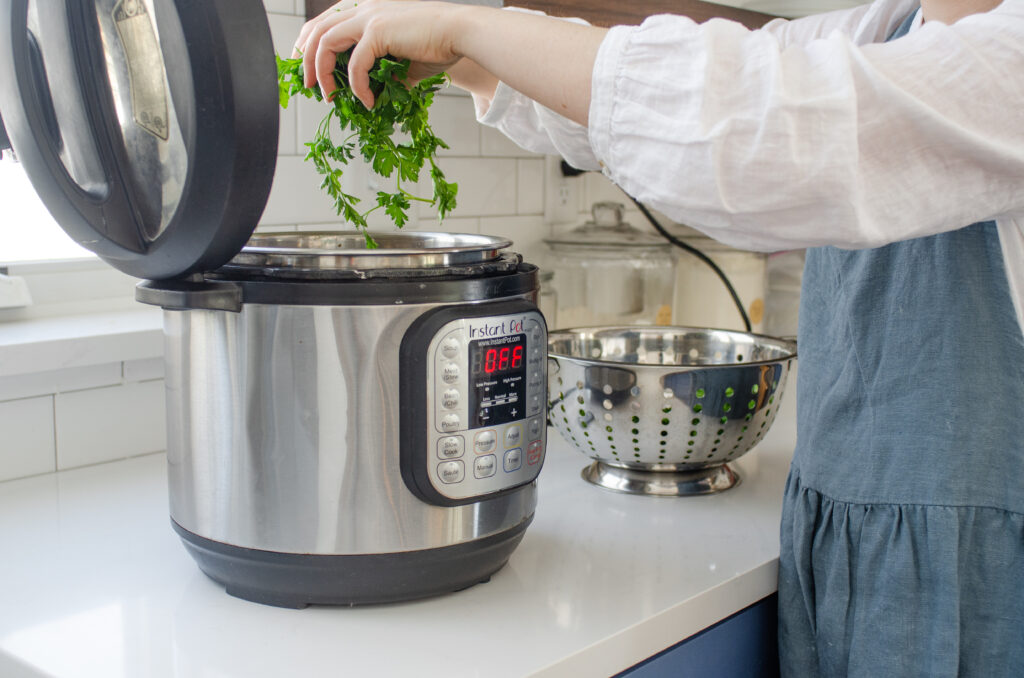 Adding fresh parsley to the chicken bone broth in the Instant Pot.