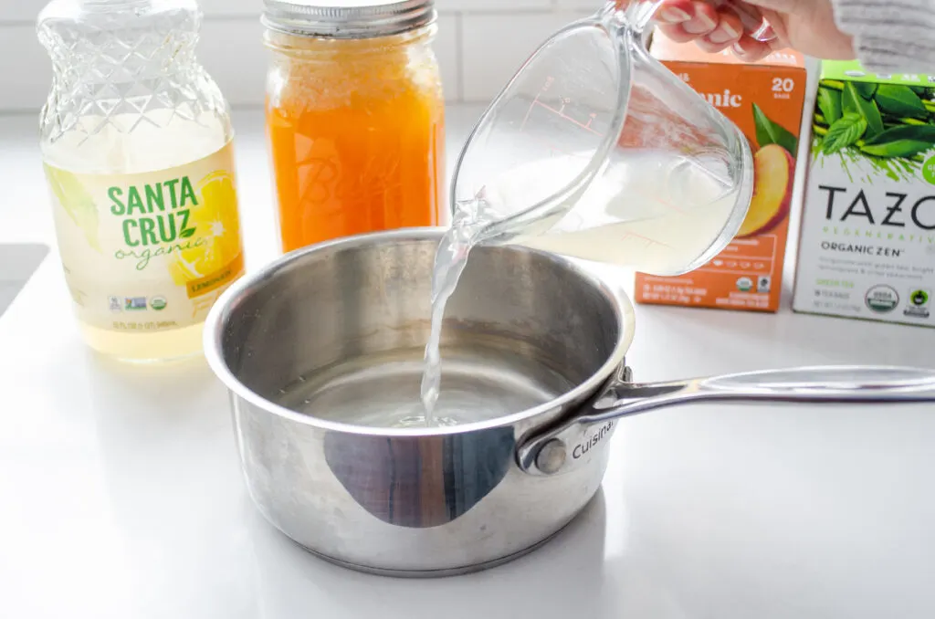 Pouring lemonade into a saucepan.