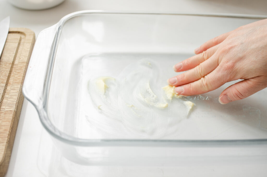 Buttering a 13x9 inch glass pan.