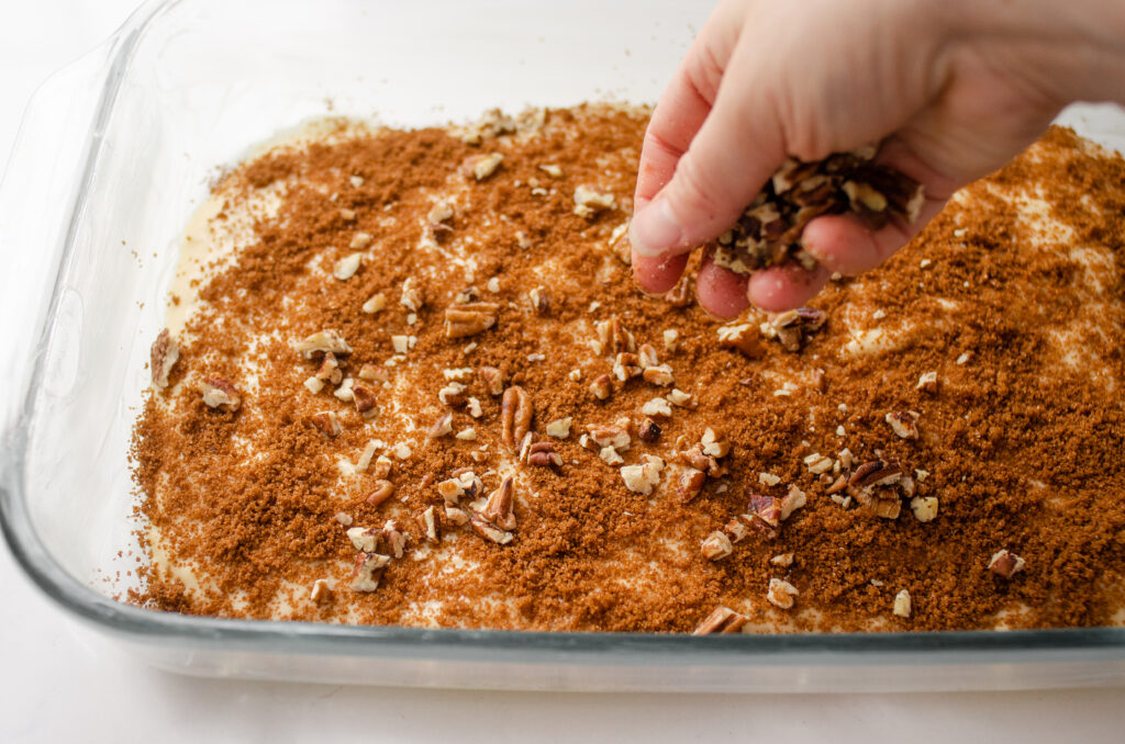 Sprinkling half of the pecans over the cinnamon sugar mixture in the pan.