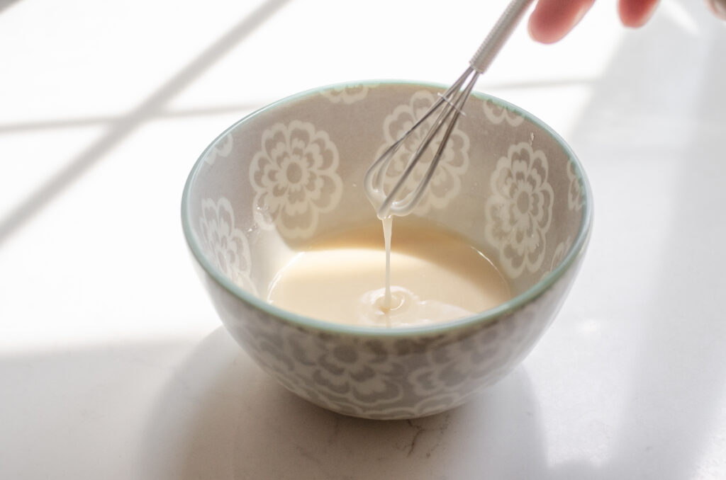 Whisking together the ingredients for the glaze in a small bowl.