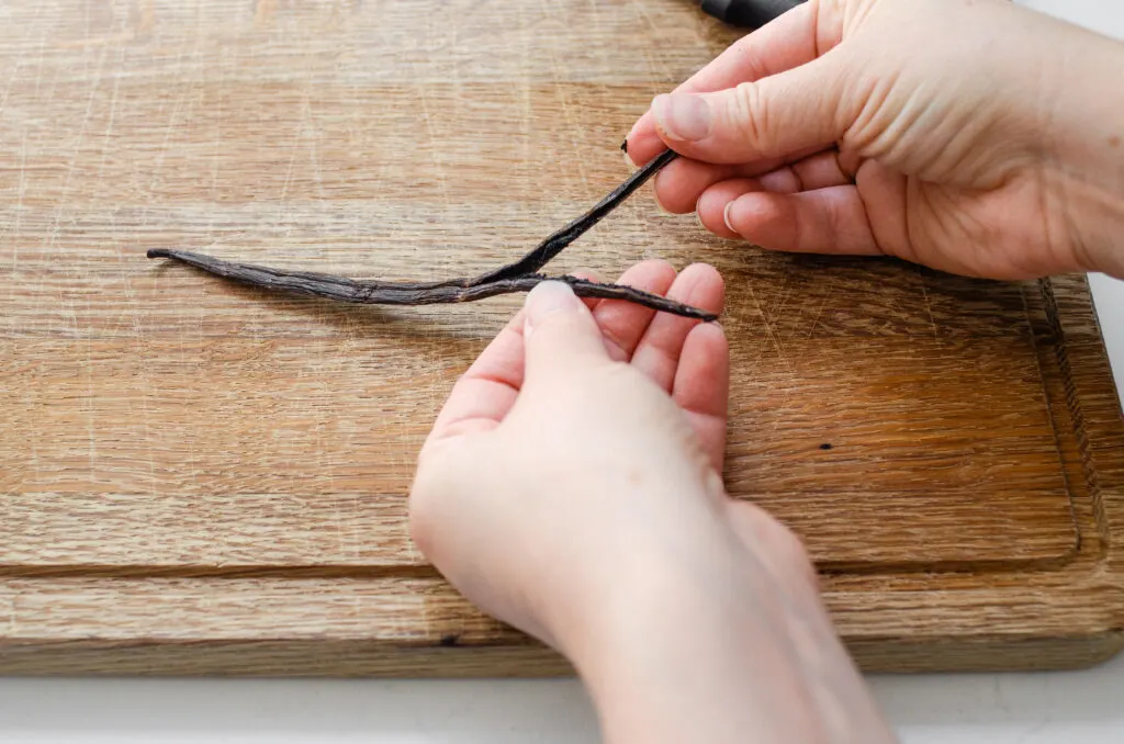Cutting a vanilla bean pod in half.