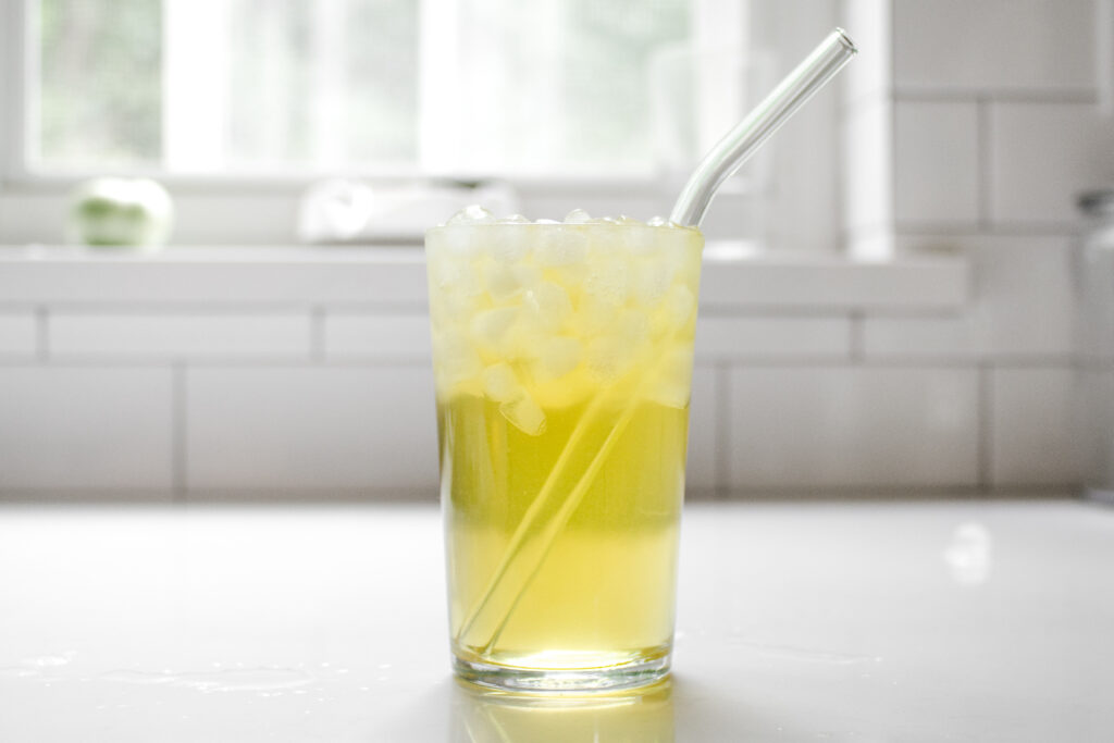 A glass of iced tea on a white countertop.