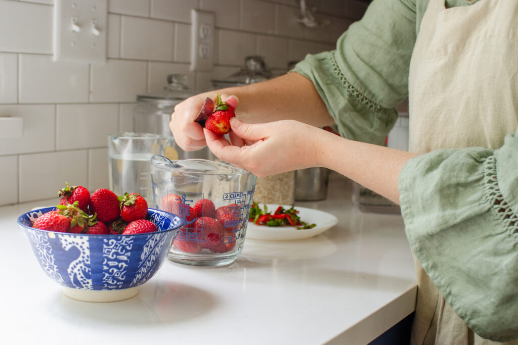 Removing the green tops from the strawberries.