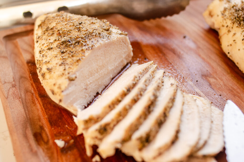 Slicing the Thanksgiving chicken breast on a wooden cutting board.