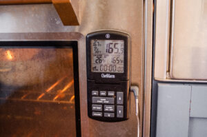 A probe thermometer magnetized to an oven.