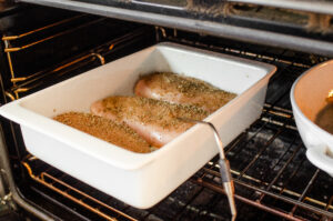 Baking the chicken breasts with a probe thermometer inserted in one of them.