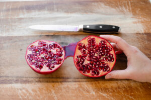 Cutting a pomegranate fruit in half.