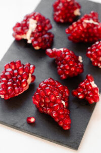 Pomegranate arils on a slate board.