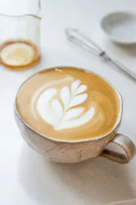 A latte made with an instant coffee espresso shot in a stoneware mug with latte art.
