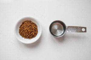 All of the ingredients needed to make a shot of espresso with instant coffee.