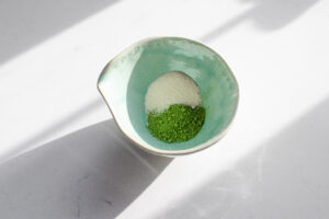 Matcha powder and cane sugar in a spouted bowl.