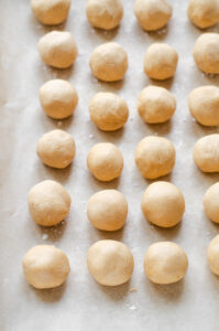 A parchment lined baking sheet with no bake peanut butter balls on it.