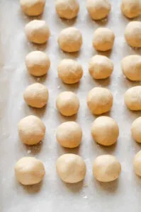 A parchment lined baking sheet with no bake peanut butter balls on it.