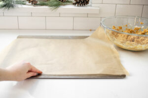 Lining a baking sheet with parchment paper.