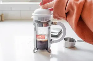 Placing the lid on the French press without plunging it down.