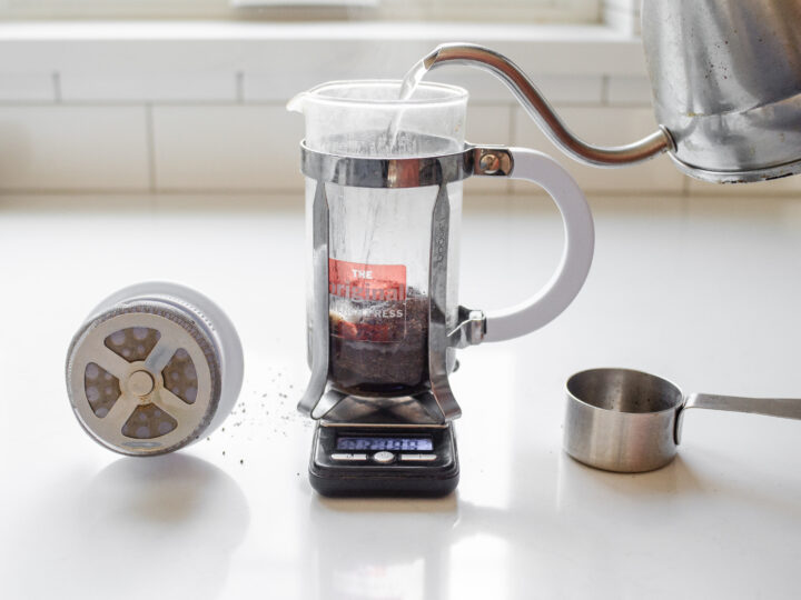 Adding hot water to the ground coffee in the French press.