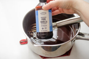 Adding the vanilla extract to the boiled chocolate syrup.