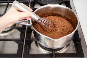 Stirring the chocolate syrup ingredients over the stove.