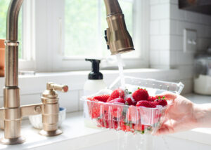 Washing a quart of strawberries.