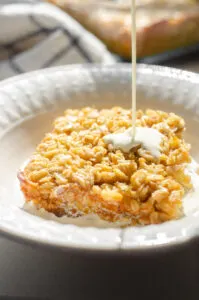 Pouring cream on top of baked oatmeal.