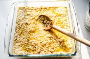 Mixing the baked oatmeal batter in with the melted butter in the pan.