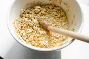 Mixing together the wet and dry ingredients in a bowl.