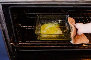 Pulling the melted butter out of the oven.