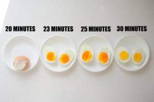 Baked hard boiled eggs in bowls to show what different baking times result in.
