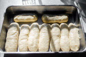 The formed hotdog buns in a 9x13-inch pan.