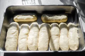 The formed hotdog buns in a 9x13-inch pan.