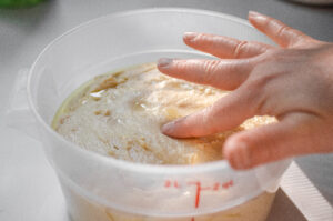 Performing the poke test to see if the dough is done fermenting.