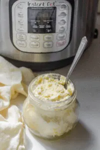 A jar of clotted cream with a spoon inside and an Instant Pot behind it.