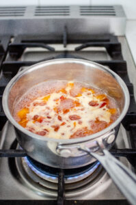 Cooking the peach syrup over the stove.