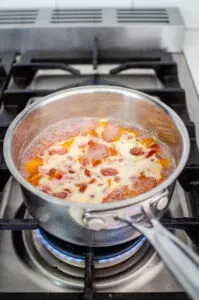 Cooking the peach syrup over the stove.