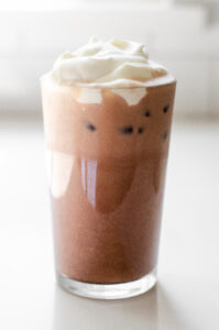 A glass of homemade Starbucks iced mocha latte on a white countertop.