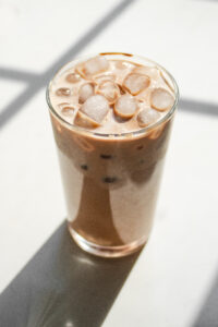 A glass of homemade Starbucks mocha iced latte on a sunny white countertop.