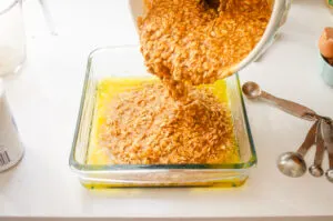 Pouring the batter over the melted butter in the pan.