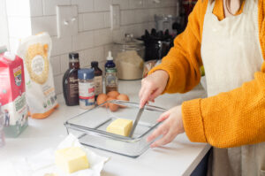 Placing 1/2 cup of butter in a square baking dish.