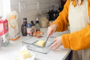 Placing 1/2 cup of butter in a square baking dish.