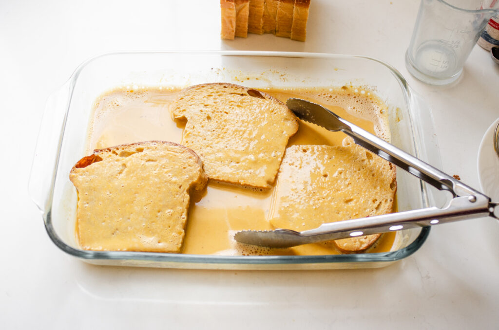 Soaking the slices of bread in the custard mixture.